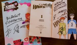 Pôster e mangá Haikyu!! autografados pela banda Burnout Syndromes no Anime Friends 2026.